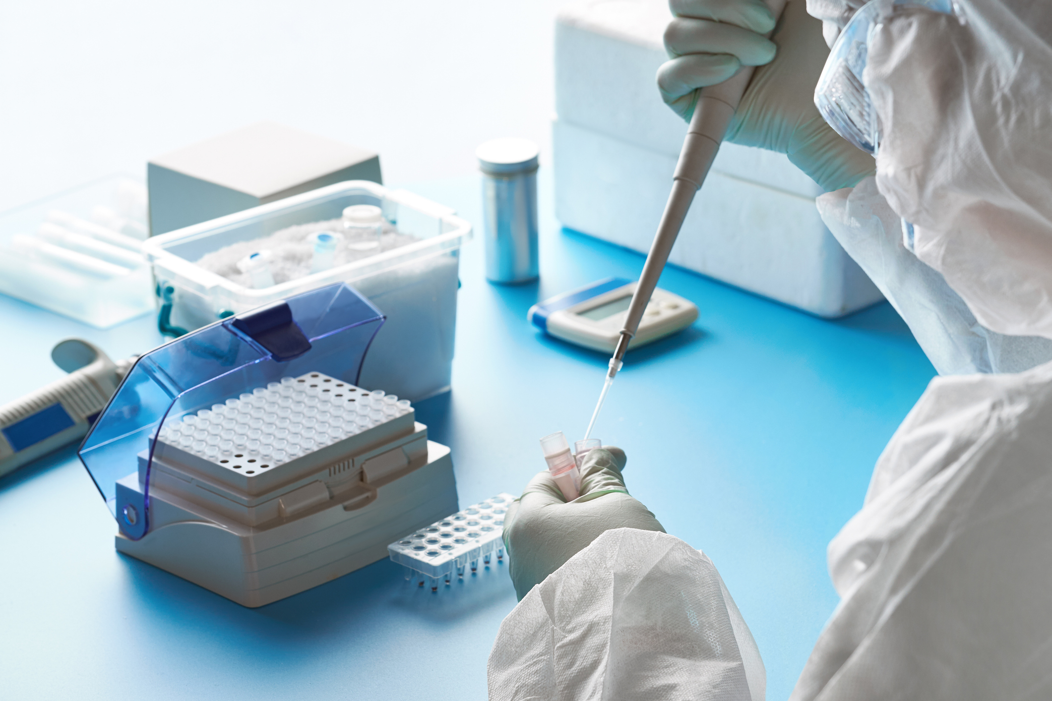 Epidemiologist in protective suit, mask and glasses works with patient swabs to detect specific region of 2019-nCoV virus causing Covid-19 viral pneumonia. SARS-COV-2 pcr diagnostics kit concept. Image credit: iStock