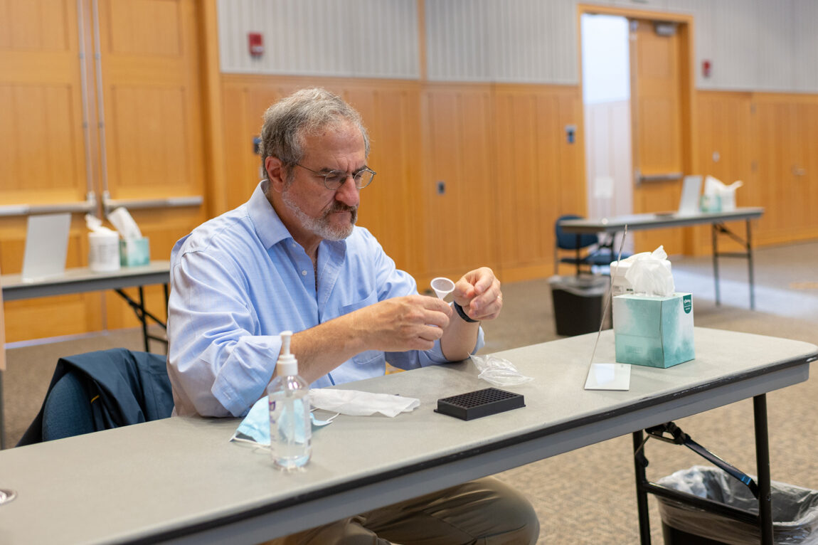 Photo of President Mark Schlissel preparing to take a saliva-based COVID-19 test.