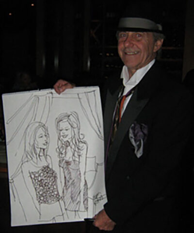 Gary Bohas, a stockkeeper at the U-M Central Power Plant, shows off a portrait he created, one of thousands of drawings of celebrities and strangers he’s drawn on paper napkins over the years. (Photo courtesy of Gary Bohas)