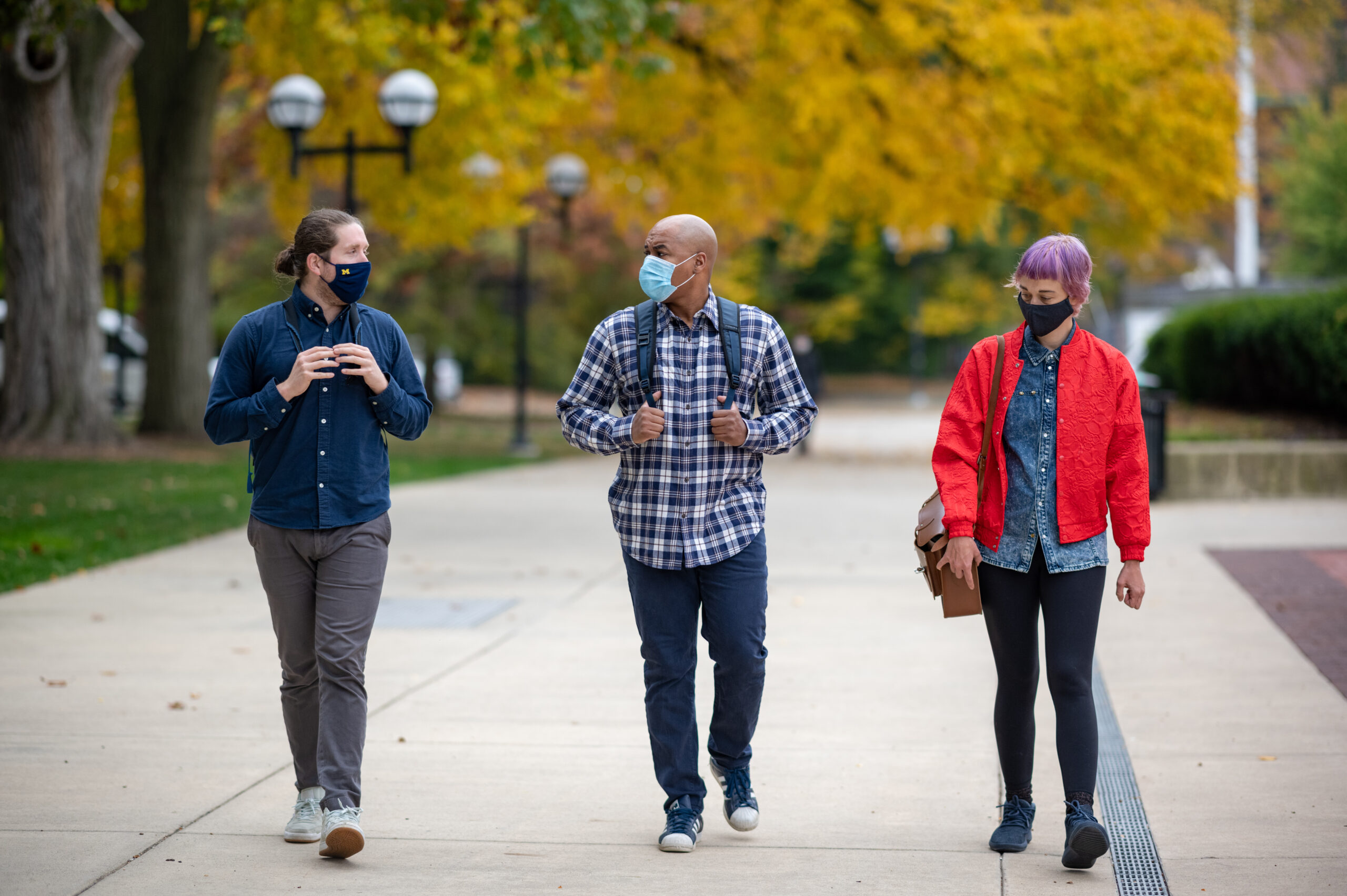 University of Michigan School of Information graduate students Joshua Tooker, Michael Payne and Lauren Trimble, (left to right) walk on campus. Image credit: Eric Bronson, Michigan Photography