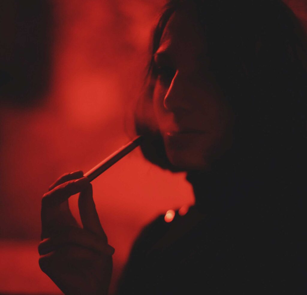 Blurred photo of a young person using a e-cig. Image credit: Elsa Donald via Unsplash