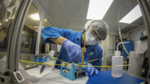 Mayukh Nath, Computer Engineering Undergraduate Student inspects the upper unit on the Mi-TEE (Miniature Tether Electrodynamics Experiment) cubesat inside a CLaSP laboratory on North Campus in Ann Arbor, MI. before it launches into Earth's Ionosphere. Image credit: Robert Coelius/ Michigan Engineering, Communications and Marketing