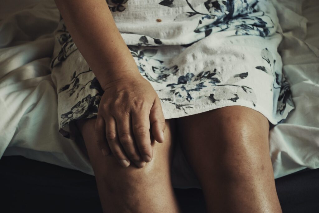 A woman's hand on her knee. Image credit: Anna Auza on Unsplash