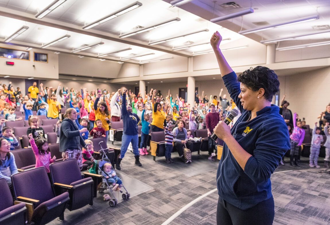 Rebecca Hasson, associate professor of movement science in the School of Kinesiology, leads children and others through song, dance and activities in 2018 during the annual MLK Children and Youth Program, which attracts K-12 student participants from school communities throughout southeastern Michigan. (Photo by Scott C. Soderberg, Michigan Photography)