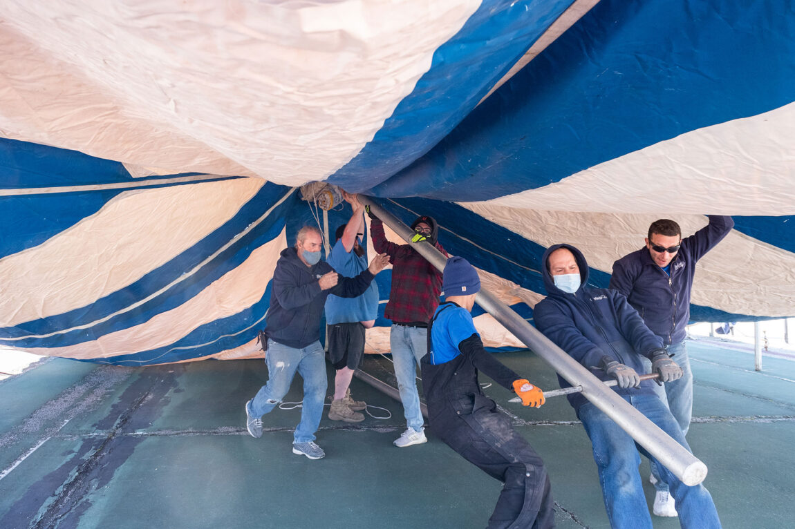 Photo of workers from Delux Tents and Events of Belleville putting up a canopy at the Palmer Tennis Courts