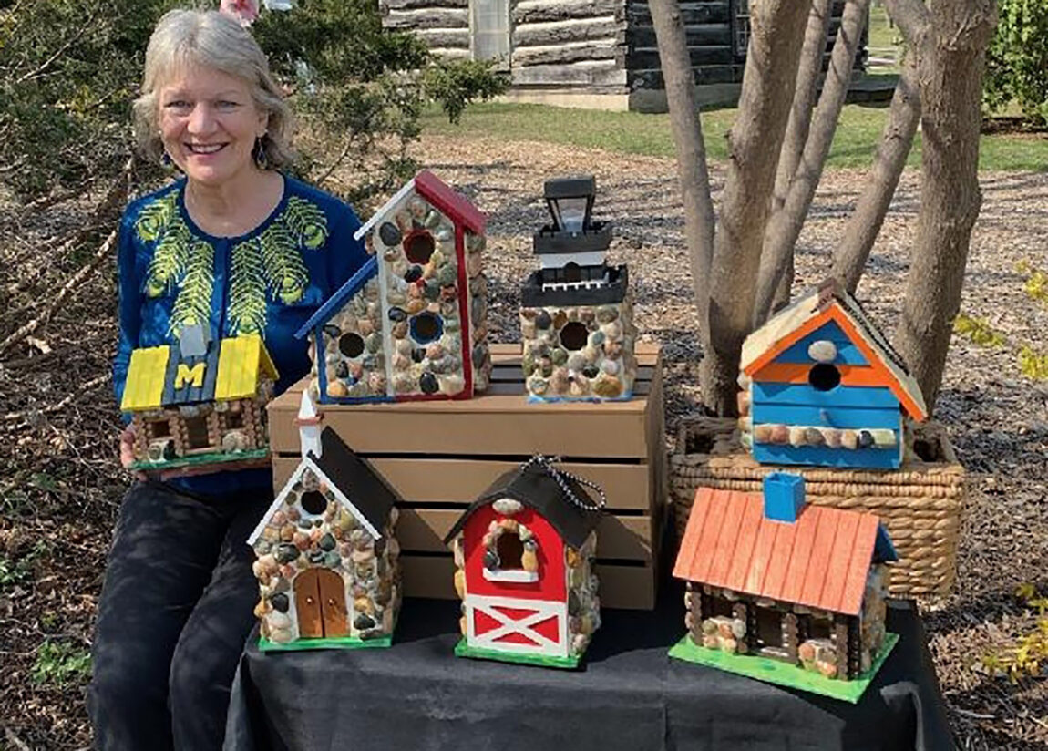 Sally Sivrais, research administrator senior manager at PM&R in the Medical School, poses with several birdhouses she’s built, painted and decorated with stones she picked up from Lake Michigan and Lake Superior beaches. (Photo courtesy of Sally Sivrais)