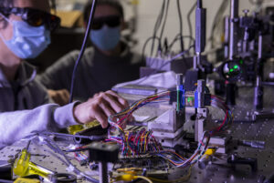 Zhen Xu, Graduate Student Research Assistant for Electrical Engineering and Computer Science (left) and Dehui Zhang, Graduate Student Research Assistant for Electrical & Computer Engineering measuring focal stack images of a point object simulated by focusing a green laser beam onto a graphene-based transparent photodetector array inside Ted Norris’ lab on North Campus in Ann Arbor, MI on January 27, 2021. Graphene detectors produce surprisingly high photoresponse while only absorbing a very small portion of light. U-M researchers are fabricating a prototype of transparent photodetector arrays to demonstrate its potential applications in 3D object tracking tasks used most commonly in autonomous driving and robotics. Image credit: Robert Coelius/Michigan Engineering, Communications and Marketing