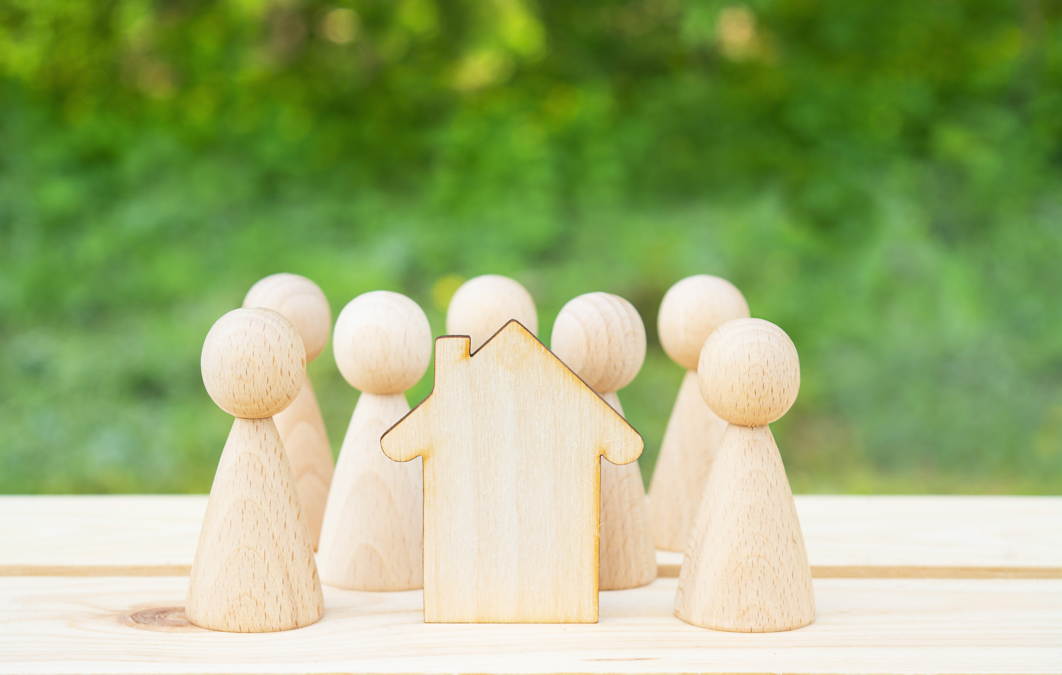 Family concept. Wooden house and many little men on a wooden table. Property division. Image credit: Yulia Romashko, iStock