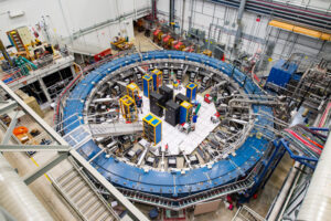 The Muon g-2 ring sits in its detector hall amidst electronic racks, the muon beamline and other equipment. The experiment operates at negative 450 degrees Fahrenheit. Image credit: Reidar Hahn