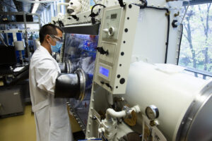 Michael Wang, materials science and engineering Ph.D. candidate, uses a glove box to inspect a lithium metal battery cell in a lab at the University of Michigan in 2020. Image credit: Evan Dougherty/University of Michigan Engineering