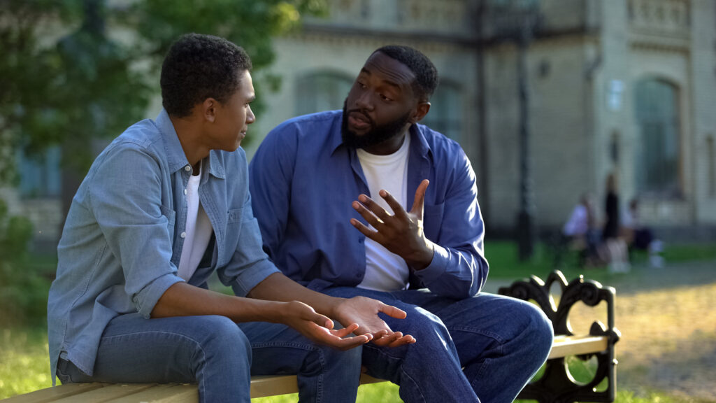 A Black father and son in conversation. Image credit: iStock