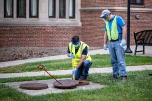 Anthony Shourds, a soil erosion and sedimentation control Specialist and Philip Szorny, an environmental engineer, both with the University of Michigan's Environment Health & Safety, collect sewage samples from Stockwell Hall in the Hill Neighborhood at U-M's Ann Arbor Campus, before students started returning to the campus in Ann Arbor. EH&S has worked closely with the School of Public Health researchers on this project.
