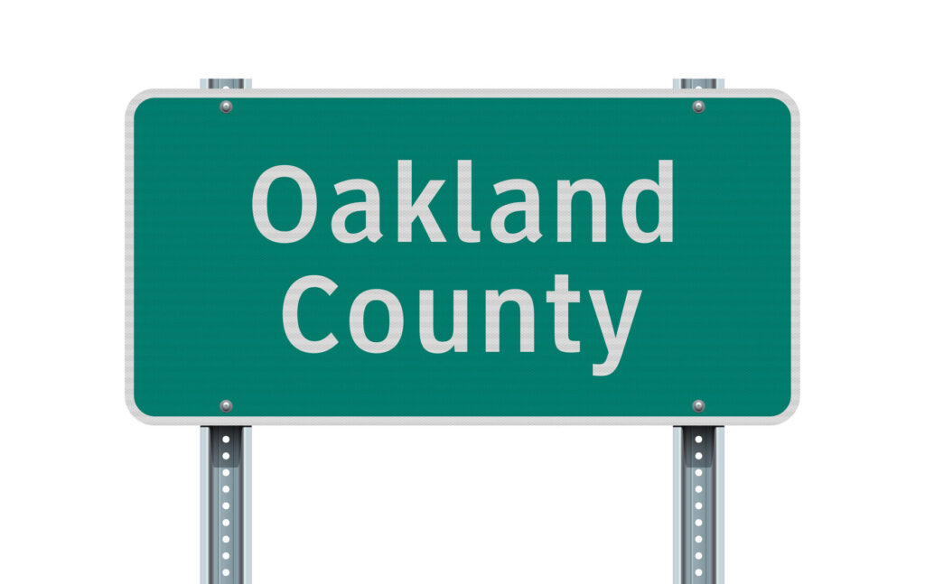 Vector illustration of the Oakland County green road sign on metallic posts. Image credit: iStock