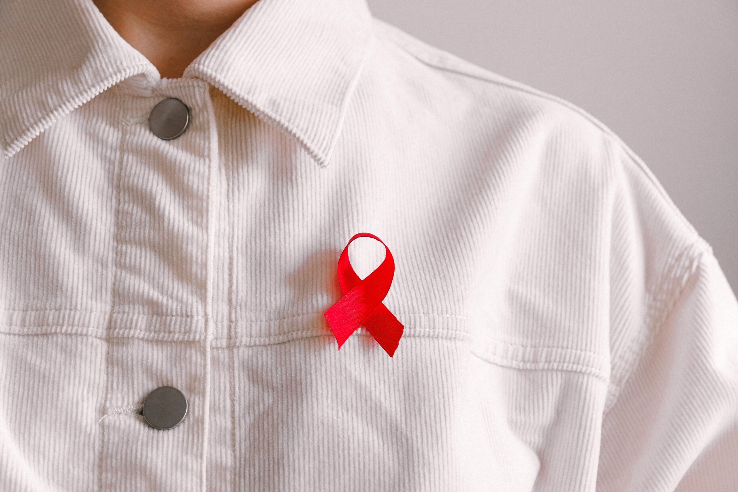 Man wearing red ribbon. Image credit: Anna Shvets, Pexels