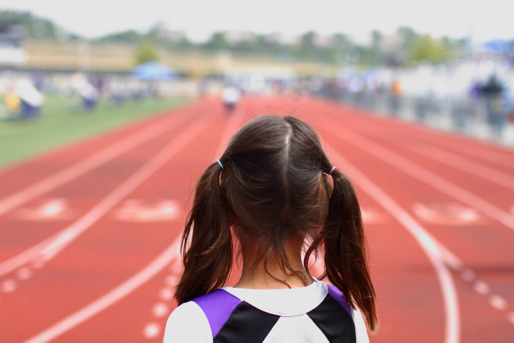 A young girl looks at a race track. Image credit: iStock