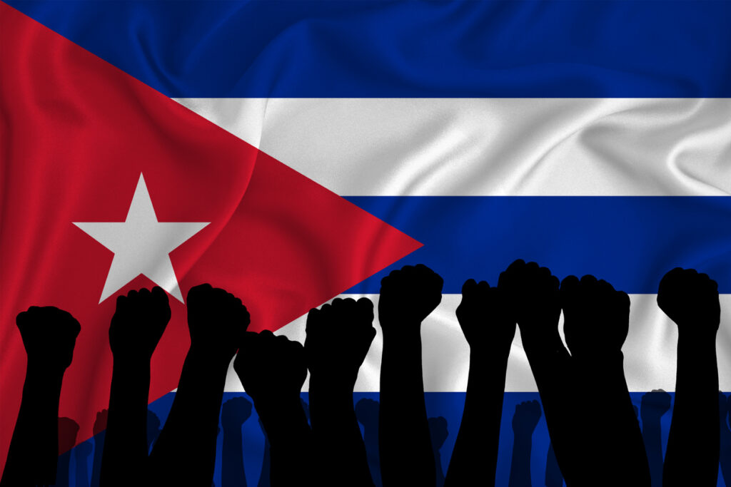 Cuban flag with protestors. Image credit: iStock