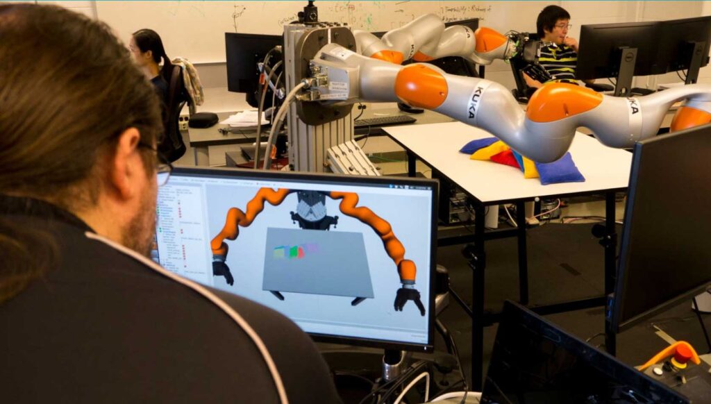 A U-M graduate student operates a KUKA robot similar to the ones used in Carol Menassa’s robot apprentice research. The $2M project aims to enable robots to learn from and cooperate with human construction workers. Image credit: Robert Coelius
