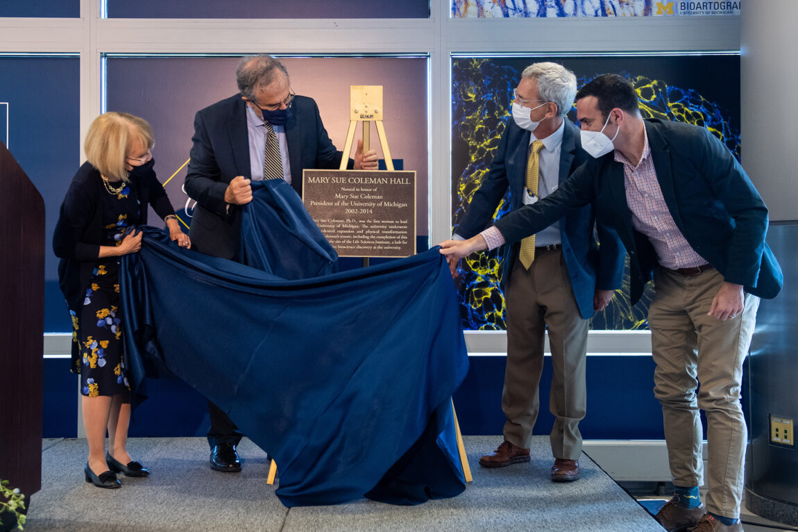 Photo of a plaque being unveiled at the naming of Mary Sue Coleman Hall