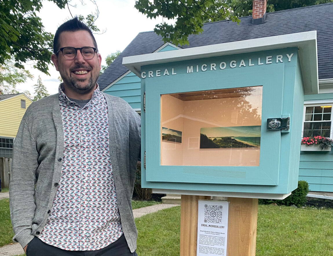 Joe Levickas, program director for Arts at Michigan and assistant director in the Office of New Student Programs, stands next to Creal Microgallery, a small art exhibit space he installed in his front yard. (Photo courtesy of Joe Levickas)