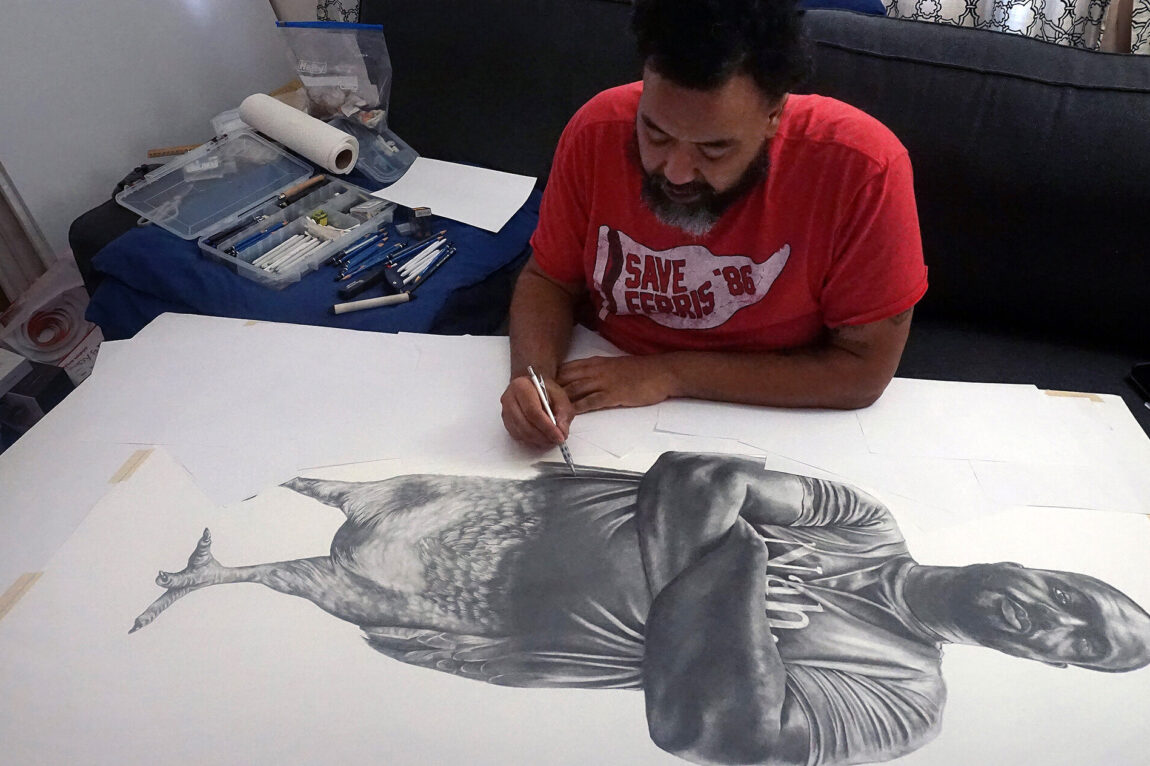 Photo of Rashaun Rucker, Detroit-based multidisciplinary artist, working on a portrait