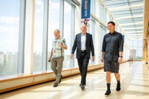Bill Lovejoy, business administration professor, (center), tells the story behind the coasters to fellow Ross School of Business professors Jeffrey Sanchez-Burks (left) and Jerry Davis.