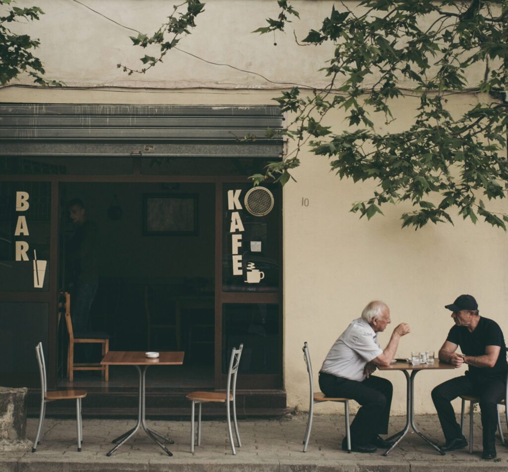 Two men talking at a cafe. Image credit: Juri Gianfrancesco, Unsplash.com