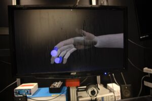University of Michigan researchers used a computer-generated hand to mirror the motions of the monkeys as they reached for the animated dots—providing data that the team used to train their algorithm for interpreting brain signals. Image credit: Marcin Szczepanski/University of Michigan Engineering