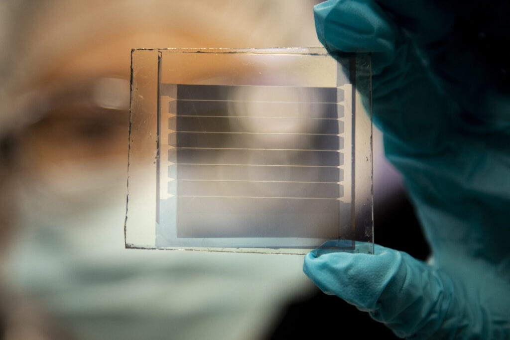 Xinjing Huang, a doctoral student in Forrest’s lab, holds a 20% transparency, 30-year solar cell module that she built.
