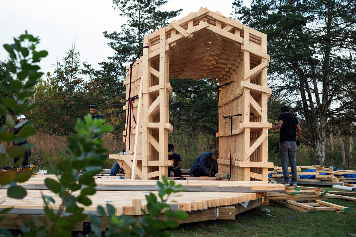 Photo of workers assembling prefabricated modules of the timber pavilion at Matthaei Botanical Gardens. 