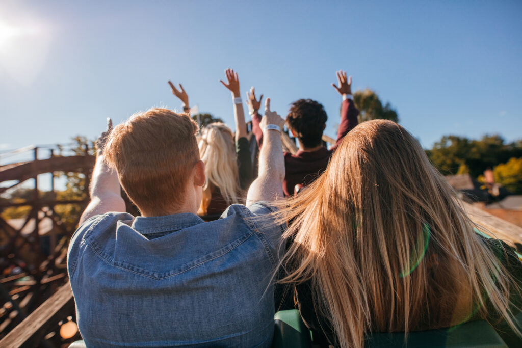 Young people on a roller coaster ride. Image credit: iStock
