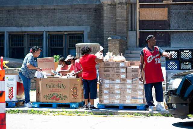 Photo of volunteers at the Historic King Solomon Baptist Church distributing food to people during a food drive.