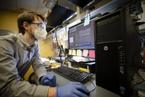 Andrew Gayle, mechanical engineering PhD candidate, monitors a device that applies atom-thick coatings to solar-transparent aerogels for use in solar-thermal power plants. Image credit: Evan Dougherty/Michigan Engineering