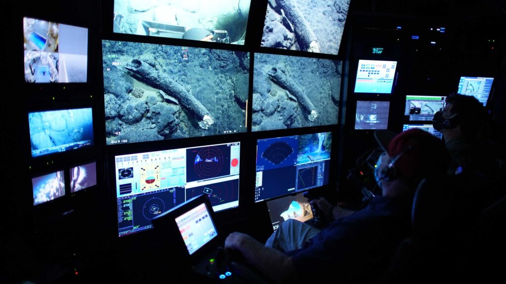 Randy Prickett (left) pilots the Monterey Bay Aquarium Research Institute's remotely operated vehicle Doc Ricketts while MBARI Senior Scientist Steven Haddock documents the mammoth tusk before beginning the retrieval operation. Image credit: Darrin Schultz © 2021 MBARI