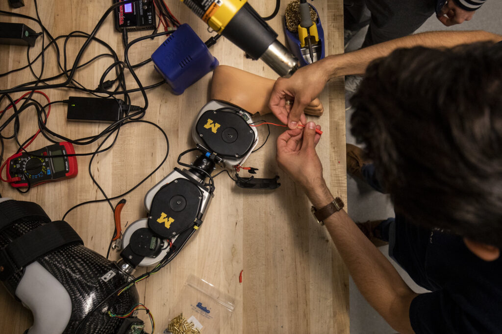 Alejandro Francisco Azocar, Mechanical Engineering Graduate Student Research Assistant puts the finishing connections together before testing an open-source robotic leg designed by Elliott Rouse, Assistant Professor of Mechanical Engineering, and his research group in the G. G. Brown Building on May 28, 2019. Image credit: Robert Coelius, Michigan Engineering