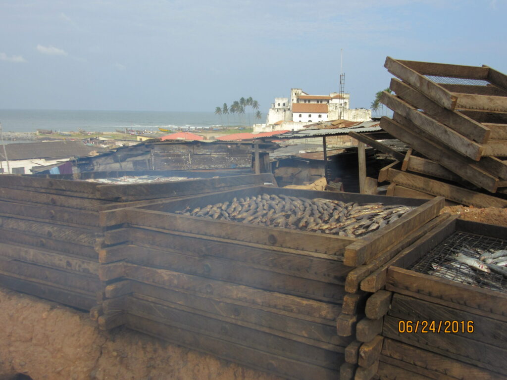 Stacked trays of fish being smoked outdoors in the coastal Ghanaian  city of Elmina. Image credit: Pam Jagger