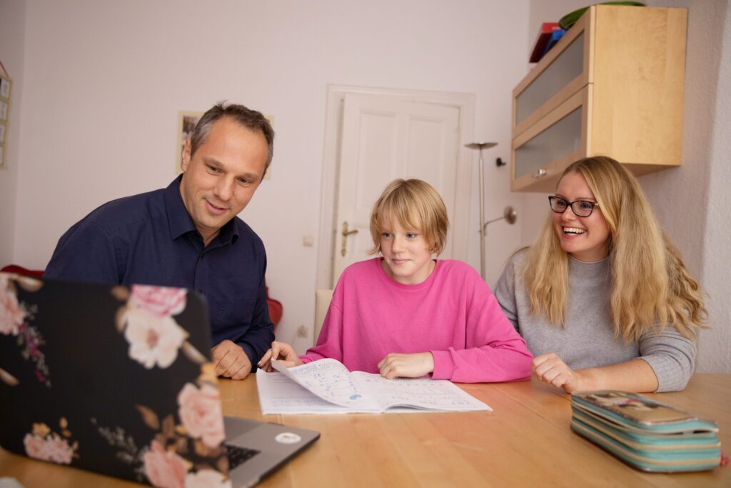 A mother, father and child using the computer. Image credit: sofatutor, unsplash.com