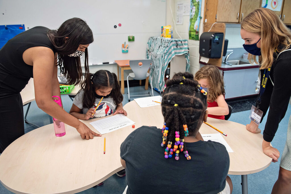 Photo of master's students working with elementary school students.