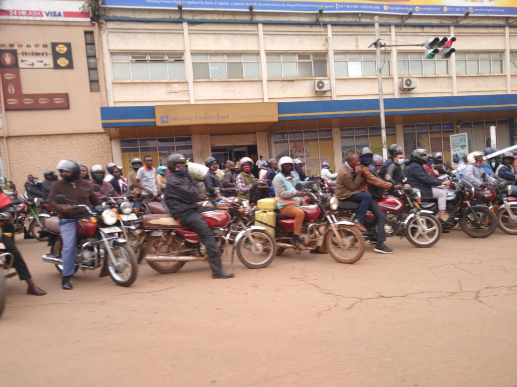 Motorcycle taxis, known as boda bodas, wait on the side of the road in Kampala, Uganda. Image credit: Tom Courtright