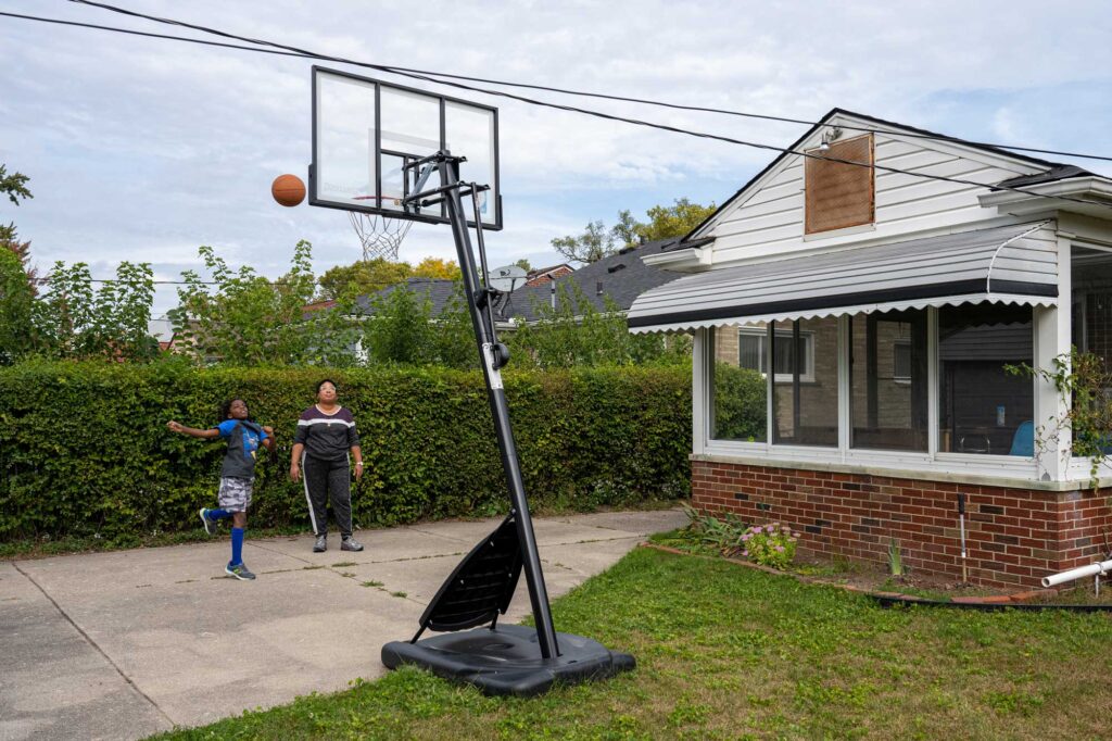 Azaan shoots baskets with family friend Alanna Price, a program associate for the Detroit Public Schools Community District. Image credit: Daryl Marshke, Michigan Photography