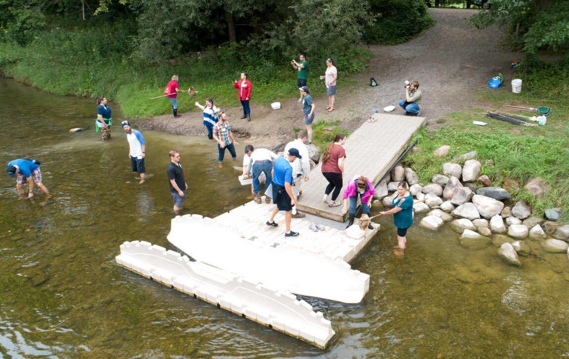The fellows sampling water from a dock.