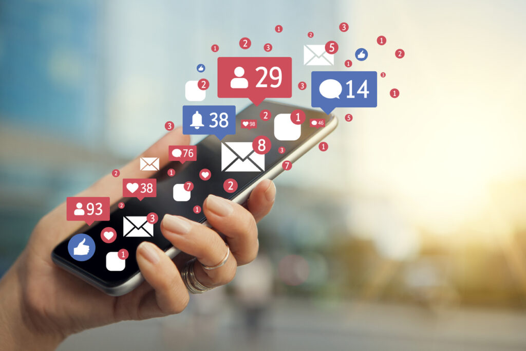 Social media notification illustrations superimposed on a phone. Image credit: iStock