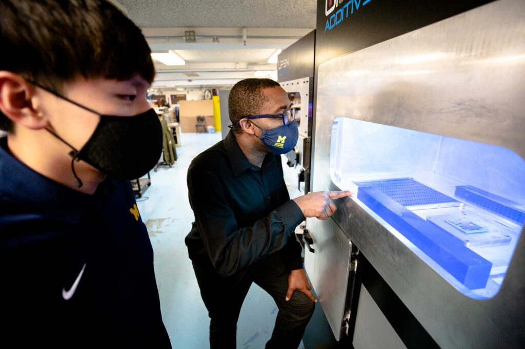 Mechanical engineering Ph.D. candidate Chuan He and associate professor Chinedum Okwudire demonstrate the laser marking procedure using a Panda 11 LPBF printer. Image credit: Evan Dougherty, Michigan Engineering