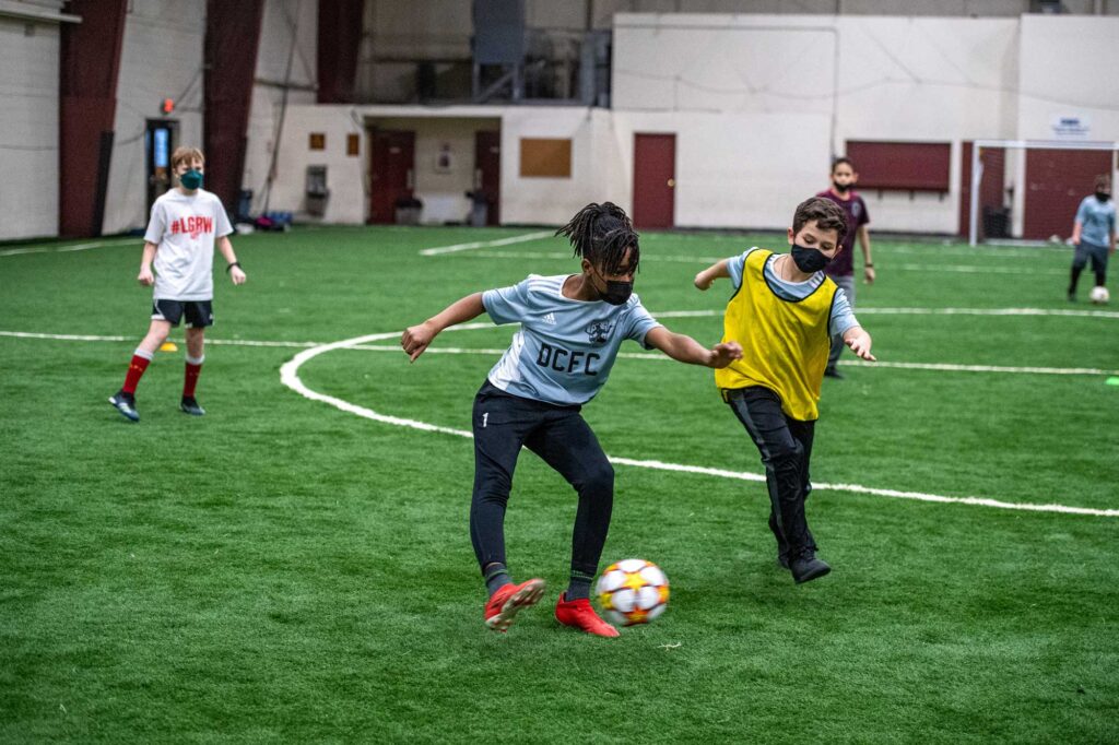 Jeremiah, 11, deftly changes speed with the soccer ball, maneuvering around defenders at the fieldhouse operated by DCFC. Image credit: Eric Bronson, Michigan Photography