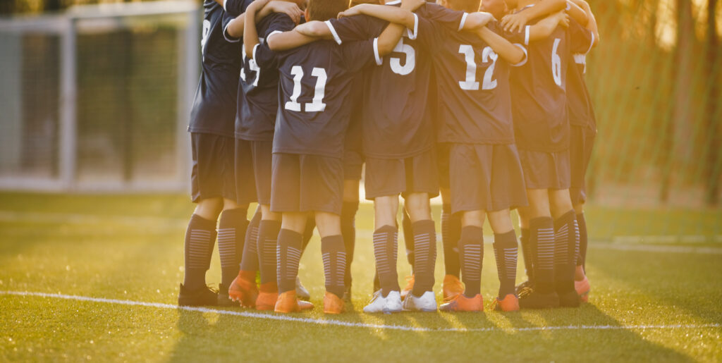 Young players huddle around the coach. Image credit: iStock