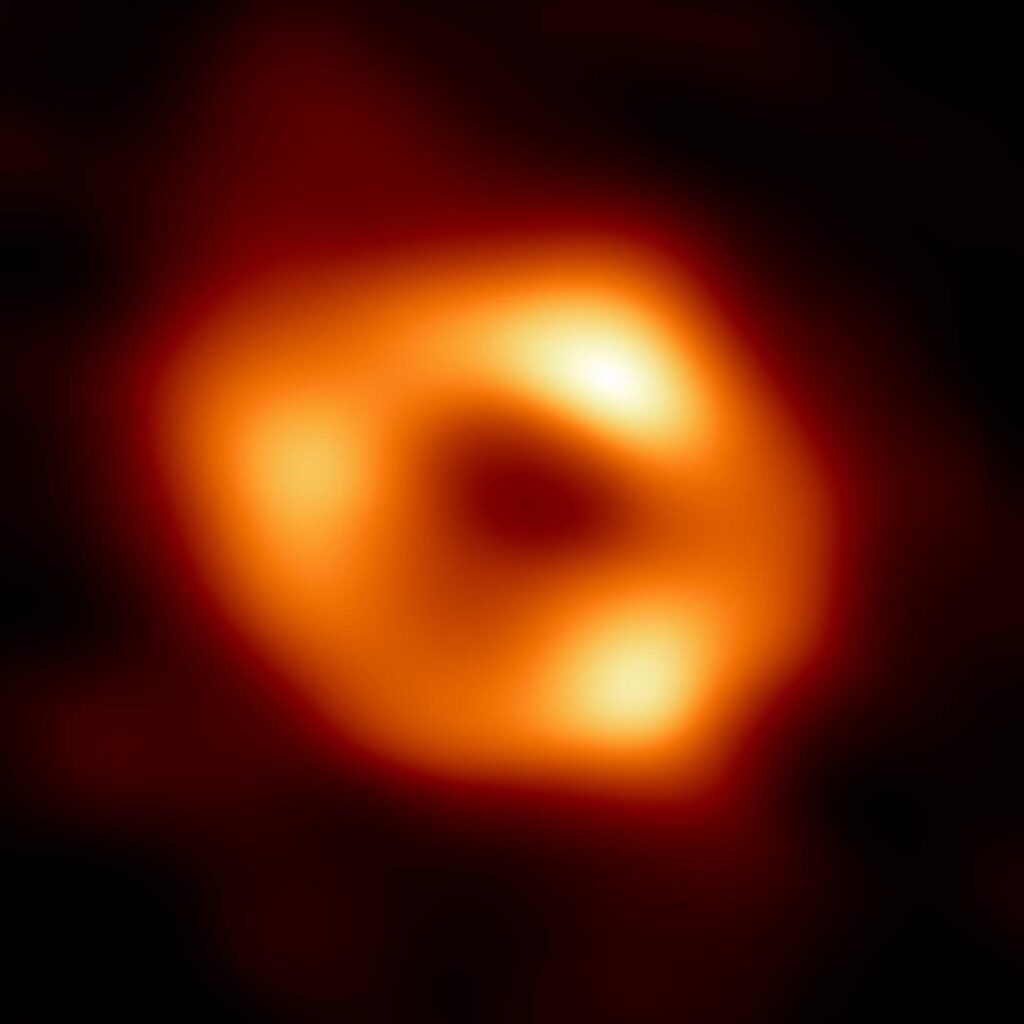 This is the first image of Sagittarius A* (or Sgr A* for short), the supermassive black hole at the center of our galaxy. It’s the first direct visual evidence of the presence of this black hole. It was captured by the Event Horizon Telescope (EHT), an array which linked together eight existing radio observatories across the planet to form a single "Earth-sized" virtual telescope. The telescope is named after the "event horizon", the boundary of the black hole beyond which no light can escape. Although we cannot see the event horizon itself, because it cannot emit light, glowing gas orbiting around the black hole reveals a telltale signature: a dark central region (called a "shadow") surrounded by a bright ring-like structure. The new view captures light bent by the powerful gravity of the black hole, which is four million times more massive than our Sun. The image of the Sgr A* black hole is an average of the different images the EHT Collaboration has extracted from its 2017 observations. Image credit: Credit: EHT Collaboration