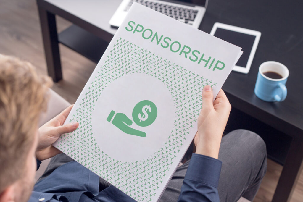 A man holding a booklet titled "Sponsorship". Image credit: iStock