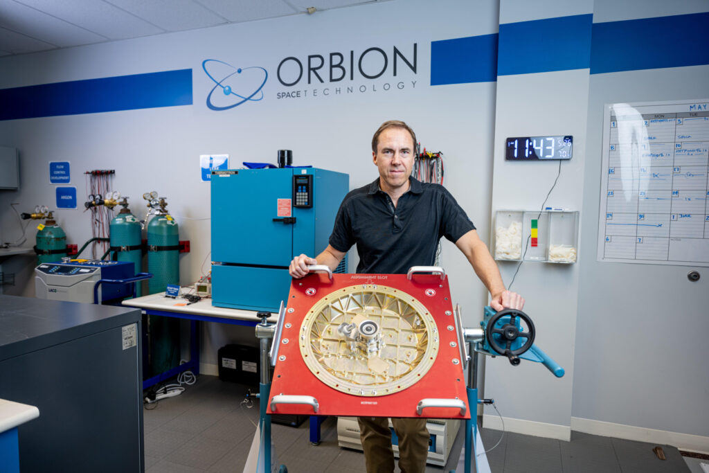 Lyon (Brad) King pictured with the plasma thruster his company designed to move small satellites around in orbit. Image credit: Michigan Photography
