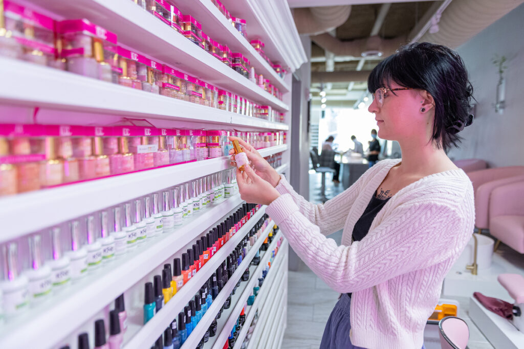 A BeeQ Salon employee selecting a nail product. Image credit: Daryl Marshke, Michigan Photography