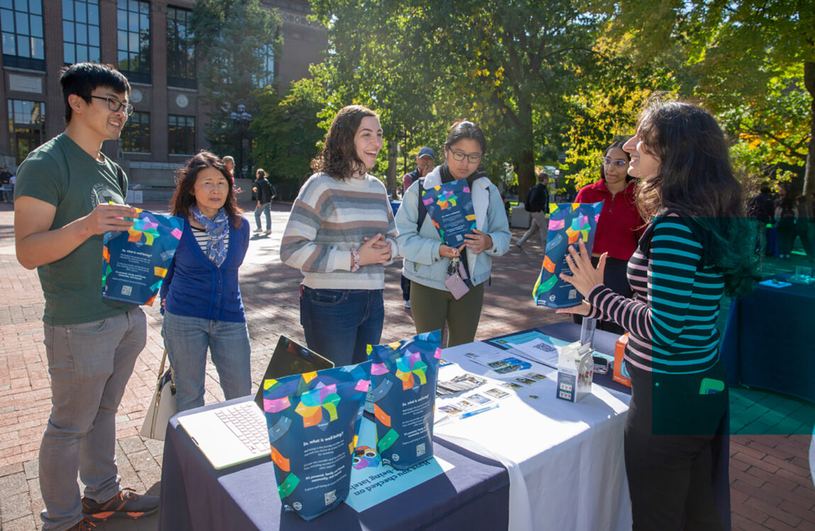 Janelle Zora, right, a health educator with University Health Service, chats with attendees at the Well-being Day at the Diag on Oct. 9. The event highlighted World Mental Health Day, which takes place Oct. 10, and encouraged students to check in on their well-being, pause and reflect on how they feel, and discover services and opportunities that are available to help them feel their best. (Photo by Rebecca Cook)