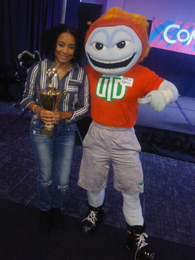 The University of Texas at Dallas mascot presents Tamara West with a first-place trophy at the school's annual Comets Got Talent competition. West, an intercultural program adviser at U-M’s Center for Global and Intercultural Study, won for her performance of a Korean ballad. (Photo courtesy of Tamara West)
